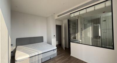 Modern bedroom with a large window and a glass wall