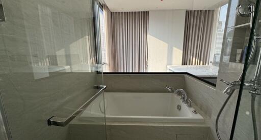 Modern bathroom with a large bathtub and a glass shower