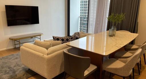 Modern living room with a dining area and a wall-mounted TV