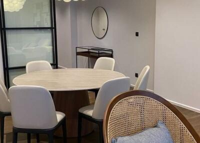 Modern dining area with round table and cushioned chairs