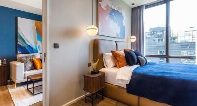 Modern bedroom with large window and blue bedspread