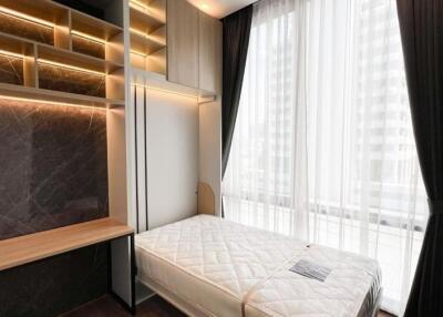 Modern, small bedroom with large windows and built-in wooden storage