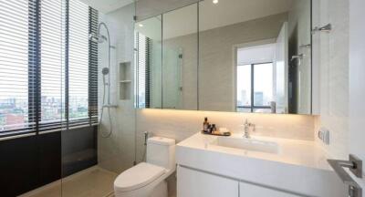 Modern bathroom with glass shower, large mirror, and white fixtures