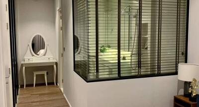 Hallway with a view into a bathroom and a small cosmetic table