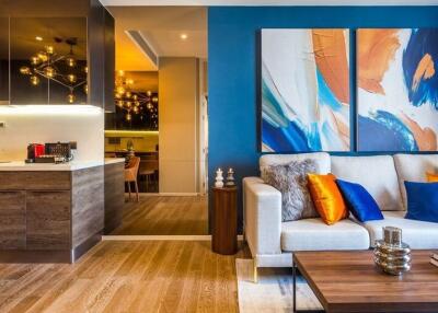 Modern living room with wooden flooring, colorful sofa and abstract wall art