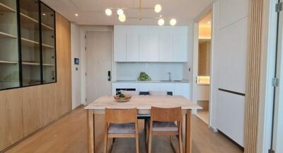 Modern kitchen and dining area with wooden elements and built-in shelving