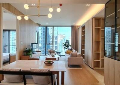 Well-lit modern living area with dining table, seating, and large windows with a city view