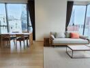 Modern living and dining area with large windows and city view