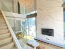 Modern living room with mezzanine, glass railing, and large windows