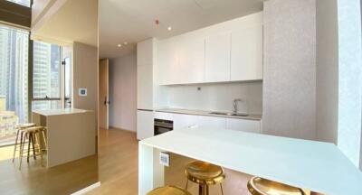 Modern kitchen with white cabinets, island, and bar stools