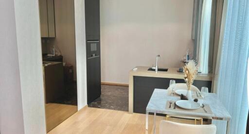 Modern dining area adjacent to a compact kitchen with contemporary appliances