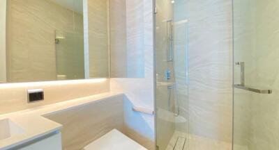 Modern bathroom with glass shower and beige tiles