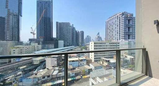 City view from a glass-railing balcony on a bright day