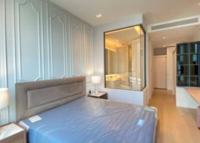 Spacious modern bedroom with a large bed, bedside tables, a large mirror, and an en-suite bathroom