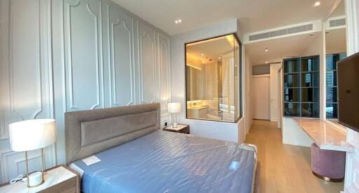 Spacious modern bedroom with a large bed, bedside tables, a large mirror, and an en-suite bathroom