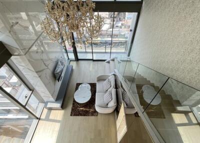 Spacious modern living room with a large chandelier and floor-to-ceiling windows