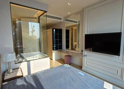 Modern bedroom with large window, TV, and ensuite bathroom