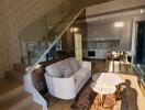 Living room with staircase, modern furniture, and kitchen view