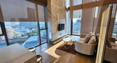 Modern living room with large windows, city view, and contemporary furnishings