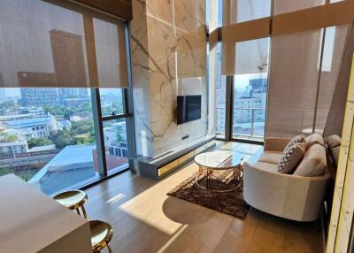 Modern, minimalist living room with large windows and a city view