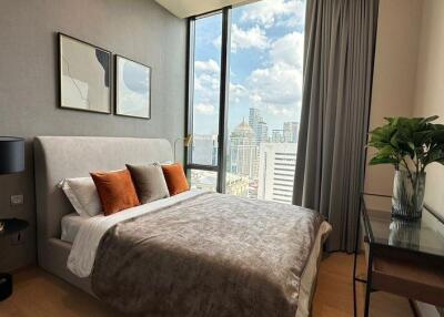 Modern bedroom with large window, city view, and stylish decor