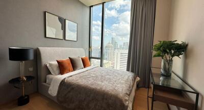 Modern bedroom with large window, city view, and stylish decor