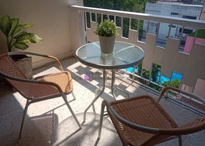 Cozy balcony with a table, chairs, and potted plant