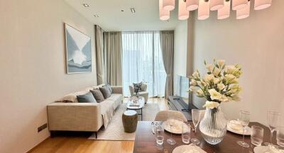 Modern living room with a dining area, large windows, and ample natural light