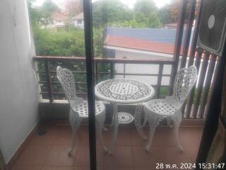 Balcony with white wrought iron table and chairs