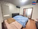 Bedroom with wooden floor, double bed, nightstand, and glass sliding doors