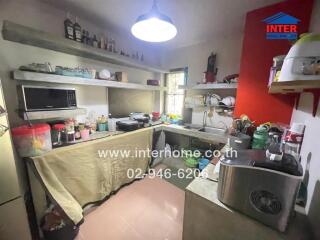 A small kitchen with various appliances and storage shelves