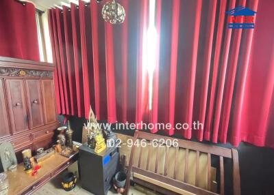 Room with red curtains and wooden furniture