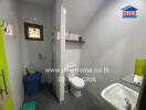 Bathroom with toilet, sink, and wall-mounted shelf