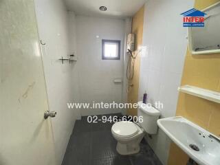 Bathroom with white tiles and basic amenities