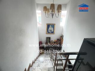 Staircase with chandelier and artwork on the wall