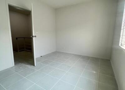 Empty bedroom with white walls and tiled floor