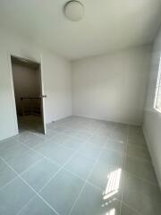 Empty bedroom with white walls and tiled floor