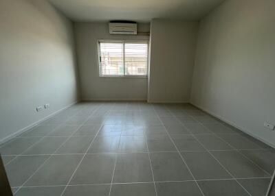 Spacious empty bedroom with tiled floors and window