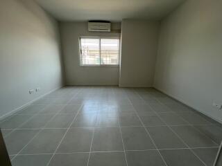 Spacious empty bedroom with tiled floors and window