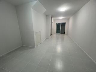 Spacious hallway with tiled flooring and recessed lighting