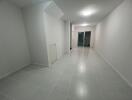 Spacious hallway with tiled flooring and recessed lighting