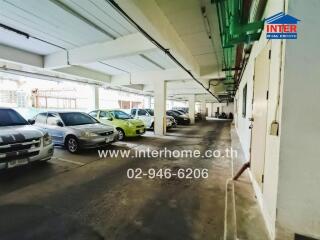 Parking garage with multiple cars and piping on the ceiling