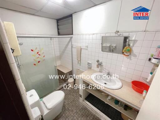 Bathroom with frosted glass shower door, sink, and toilet