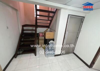 Staircase leading to upper level with storage area