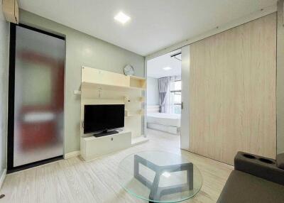 Modern living space with TV and access to bedroom
