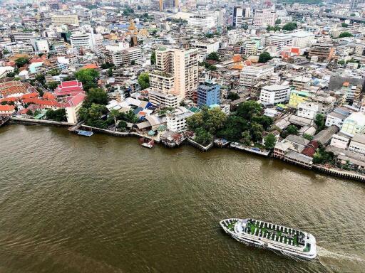 Aerial view of city buildings along a river with a boat in the water