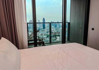 Bedroom with a view of the cityscape from a balcony