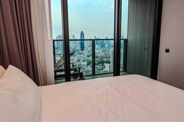 Bedroom with a view of the cityscape from a balcony