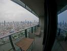 City view from a high-rise balcony with outdoor furniture