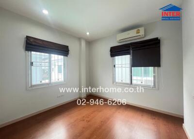 Spacious bedroom with wooden floor and air conditioning